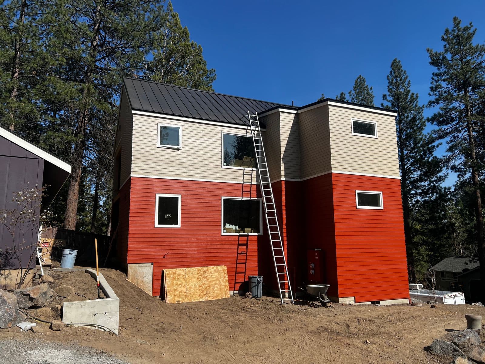 Two-story home with bold red and cream dual-tone siding and standing seam metal roof