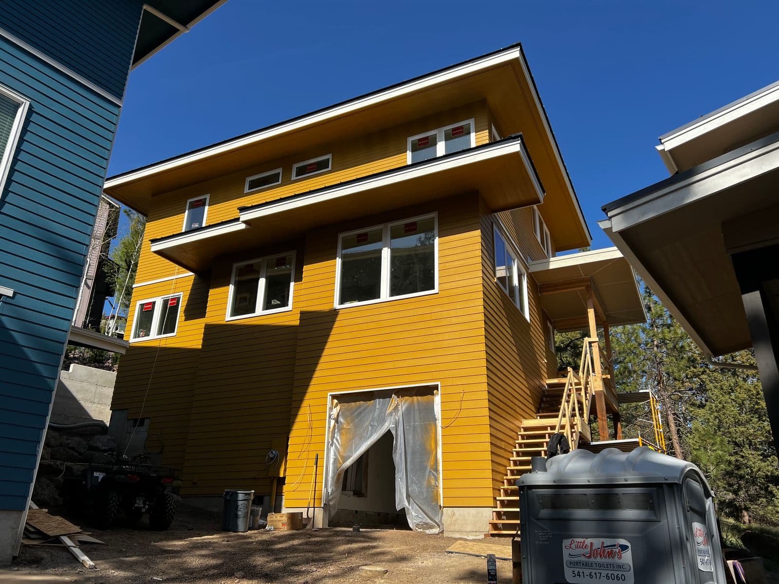 Multi-story contemporary home with yellow lap siding and modern architectural design